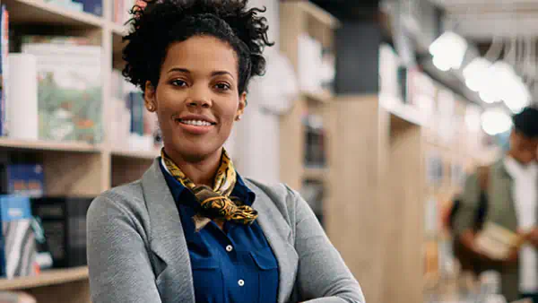 Woman poses in front of bookshelf