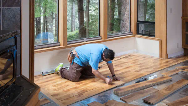 Worker installs wood flooring