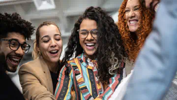 Smiling people gather together in an office